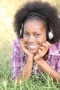 黑人妇女通过耳机听到音乐图片