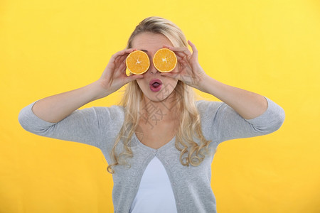 女人用橙子换眼睛背景图片