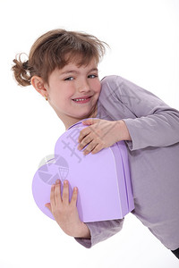 可爱的女孩拥抱一个心形的盒子背景图片