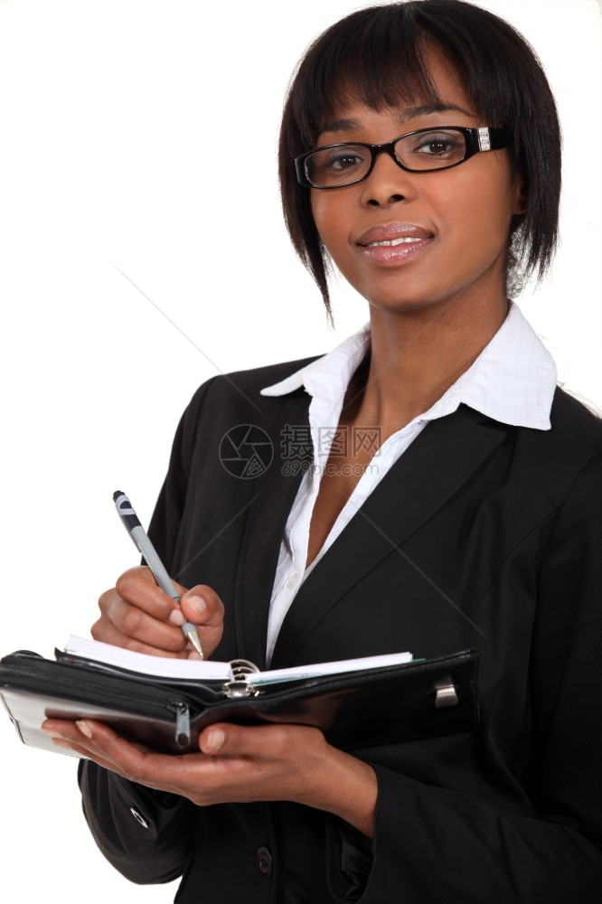 一位商业女人在计画员身上做笔记图片