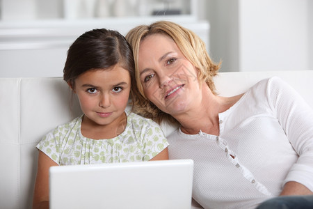 笔记本电脑上的母亲和女儿背景图片