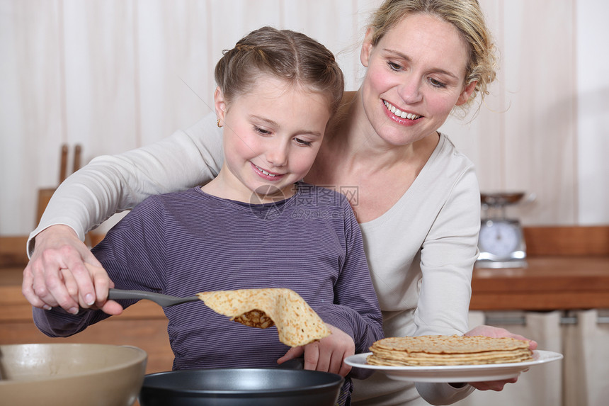 母亲和女儿一起做煎饼图片