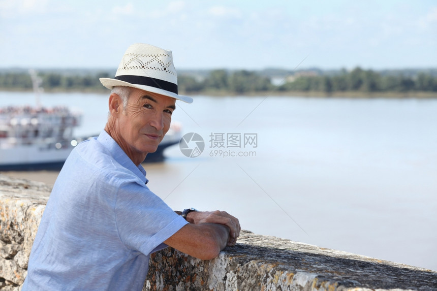 男人站在一个小港口城镇旁图片