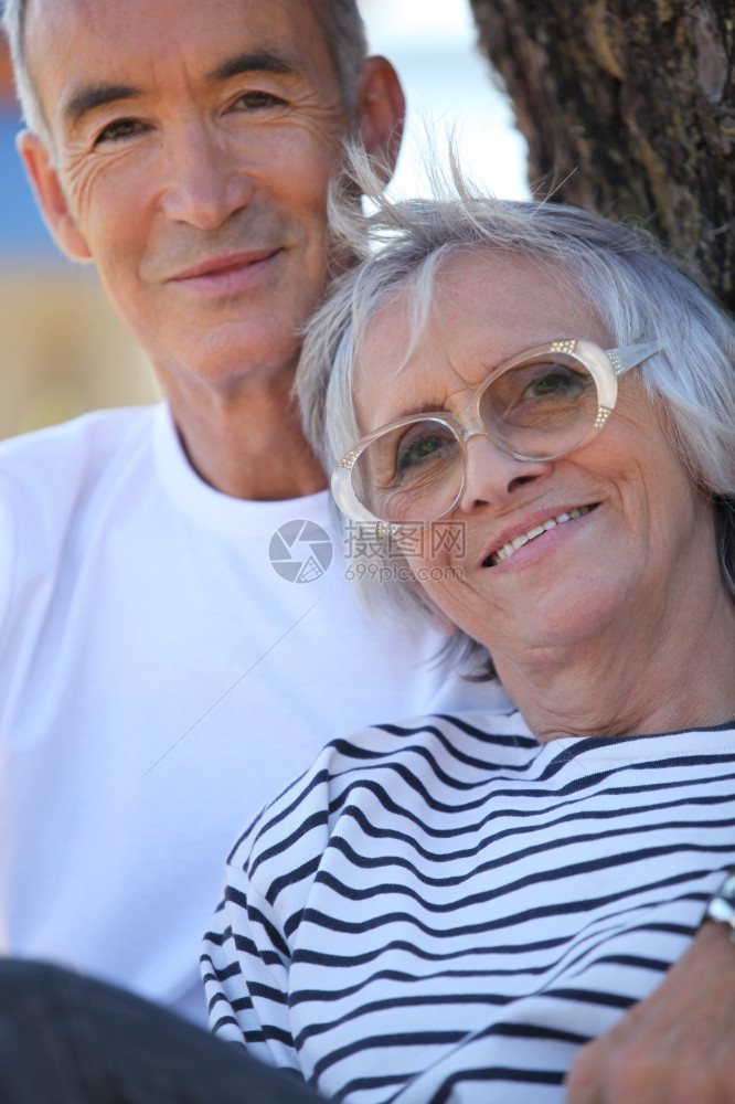 年老夫妇在公园的树旁站立图片