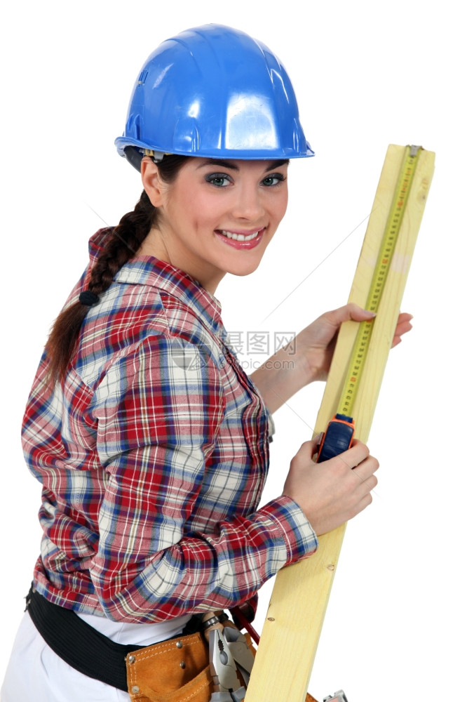 建筑工人测量一块木头图片