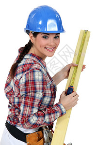 建筑工人测量一块木头图片
