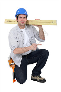 建筑工人肩上搬运木柴图片