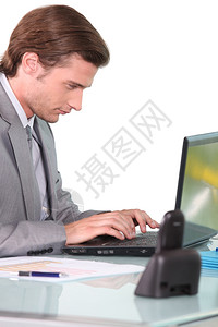 在笔记本电脑上工作的青年商人图片
