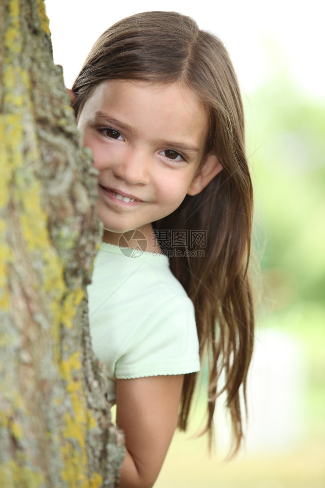 藏在树后面的年轻女孩图片