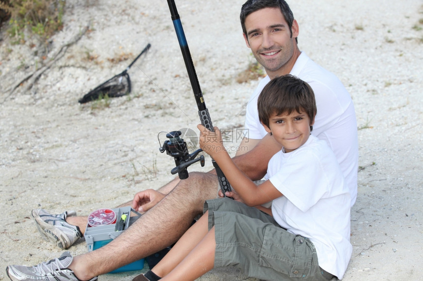 父亲和儿子在河岸捕鱼图片
