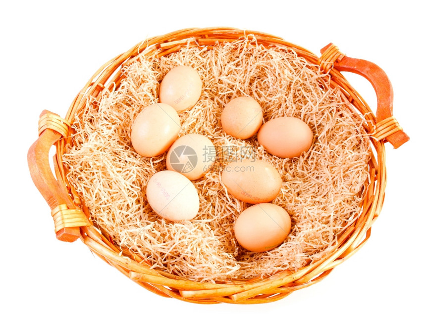 维格篮子中的回镜蛋在带稻草的维格篮子中在白色上孤立的维格篮子中在白色上方的维格篮子中在白色上方的双眼鸡蛋图片