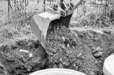 挖掘洞的机械铲土掘在地上用黑白挖洞背景图片
