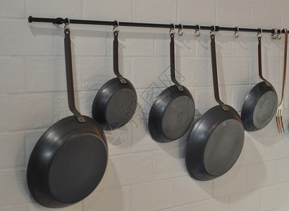 许多锅挂在厨房墙上背景图片
