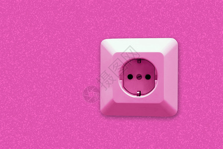 粉红色抽象背景壁上的电插座图片