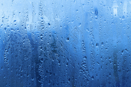 蓝色雨背景玻璃上自然水滴背景