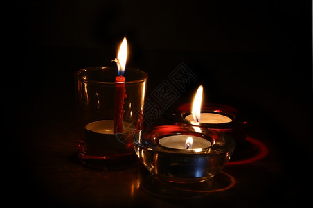 黑暗中三朵明亮燃烧的蜡烛图片