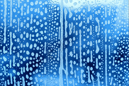 蓝底色玻璃上印有天然肥皂泡沫的玻璃型样背景图片