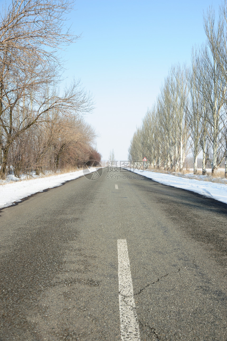 一条冬季线路边和树上下雪图片