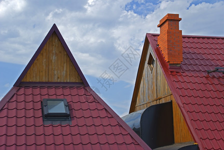 房子的屋顶覆盖着天空背景的红色瓷砖图片