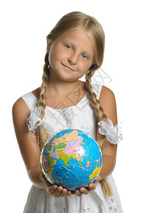 女孩手中握着从拼图收集的地球选择焦点它被隔离在白色背景上图片