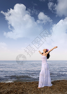 穿白衣服的女人在海边张开双手云空图片