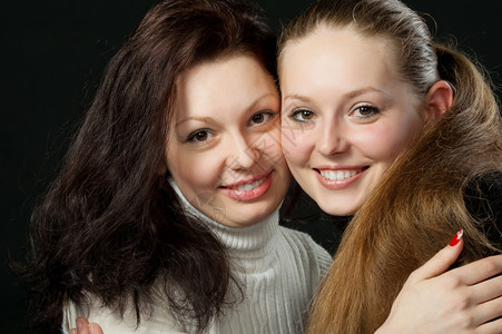 两个姐妹年轻迷人女孩的肖像黑人背景图片