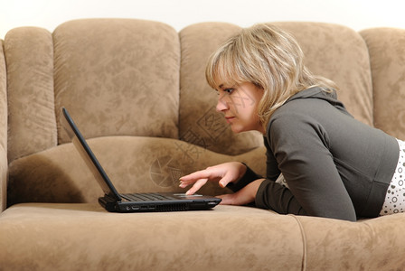 在家里用笔记本电脑工作的女人房子条件沙发图片