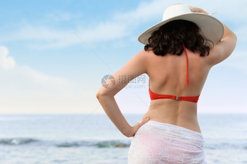 身戴帽子的海边女人后视图片