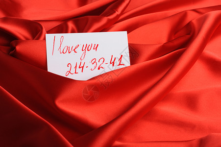 红绸上的纸条一句我爱你和一个虚构的电话号码唇膏画背景图片