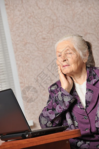 在笔记本电脑前的老年妇女图片