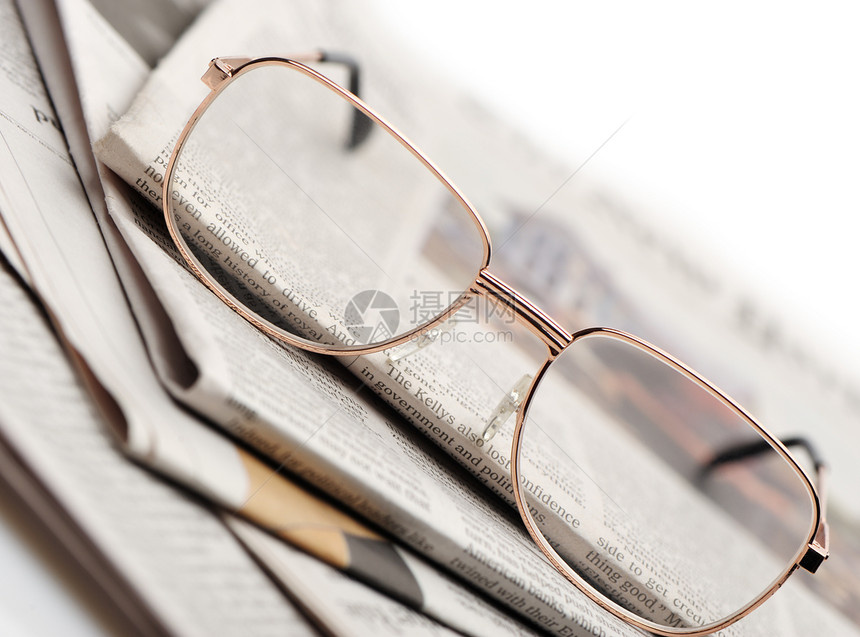 眼镜就躺在一堆报纸上照片近在眼前有选择的焦点图片