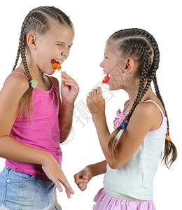 两个带着糖果的笑女孩孤立在白色背景上图片