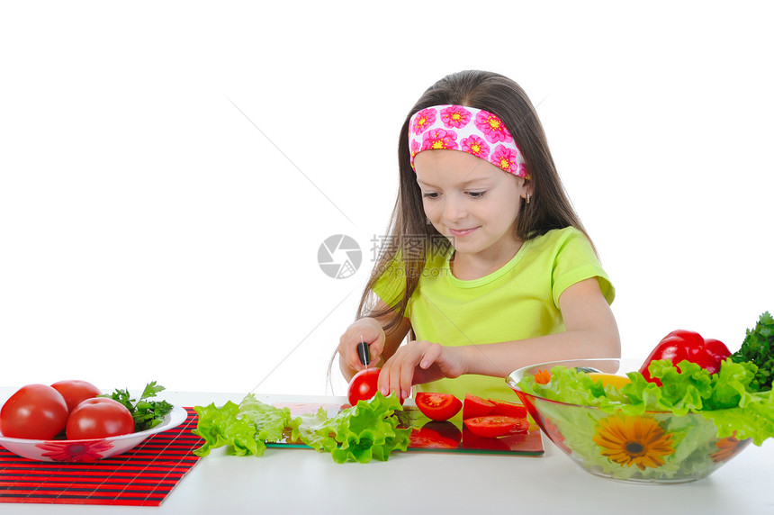 小女孩在桌子上准备沙拉孤立于白种背景图片