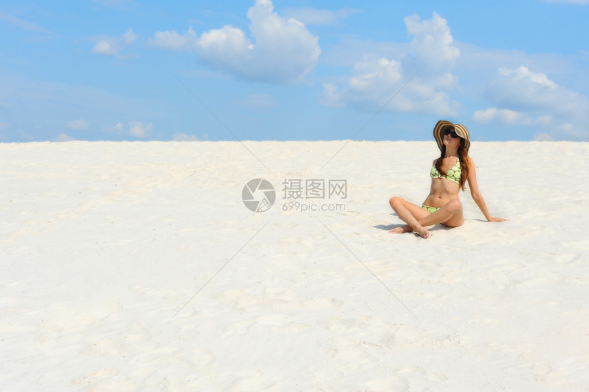 阳光明媚的海滩上美丽年轻姑娘图片