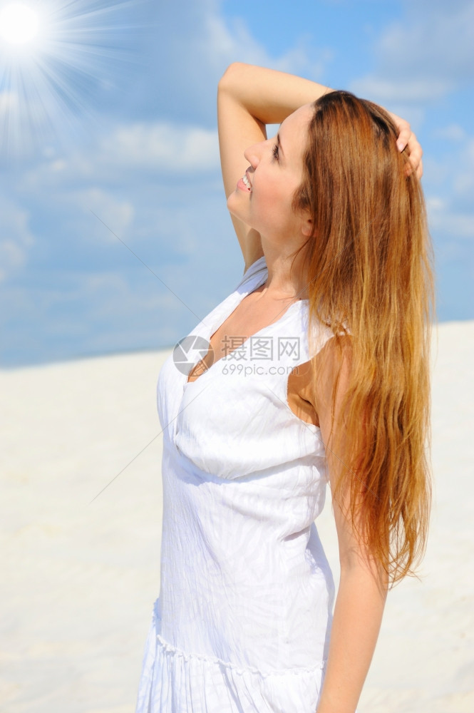 阳光明媚的海滩上美丽年轻姑娘图片