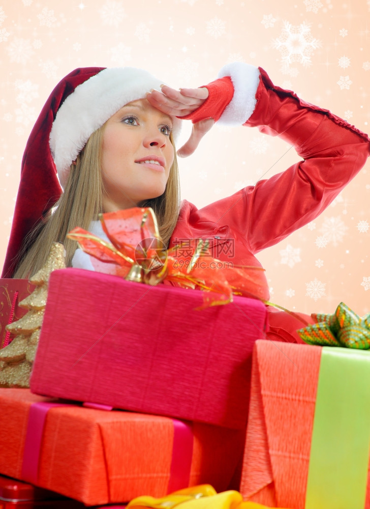 圣诞微笑的女人穿着红色圣塔帽带着礼物图片
