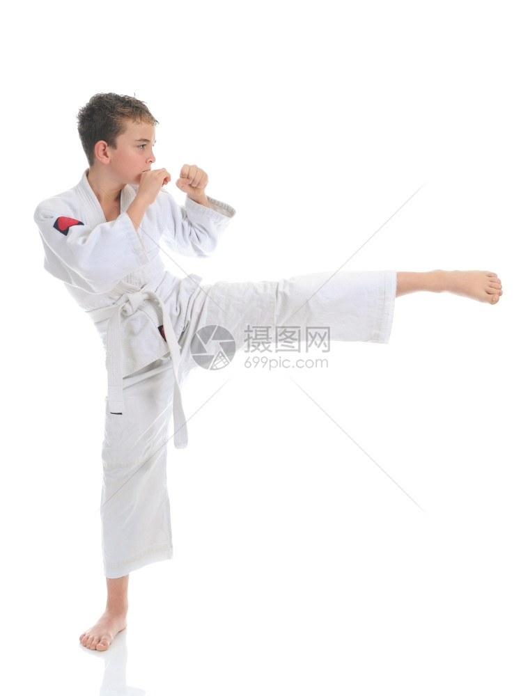 年轻男孩训练空手道孤立于白种背景图片