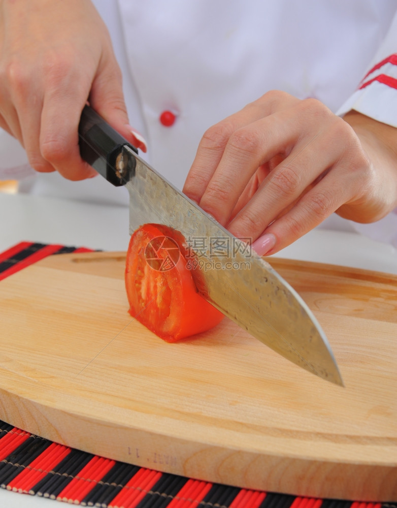 穿制服的厨师在房切番茄图片