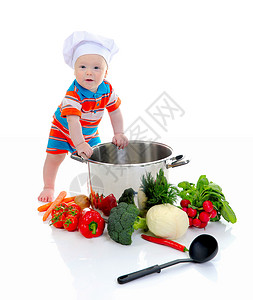 小男孩穿着厨房师的西装准备汤图片