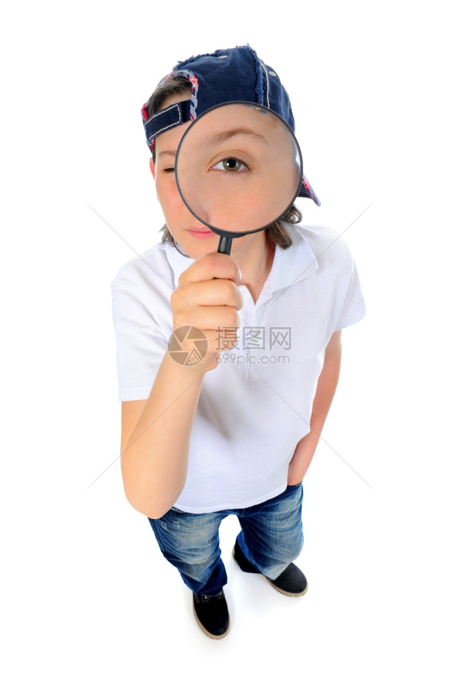 美丽的男孩透过一个放大镜寻找孤立在白色背景上的放大镜图片