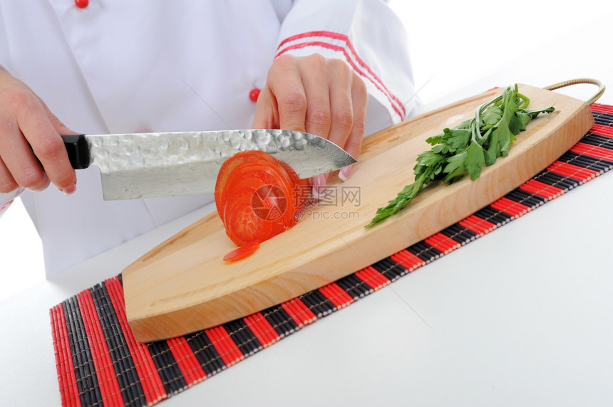 穿制服的厨师在房切番茄图片