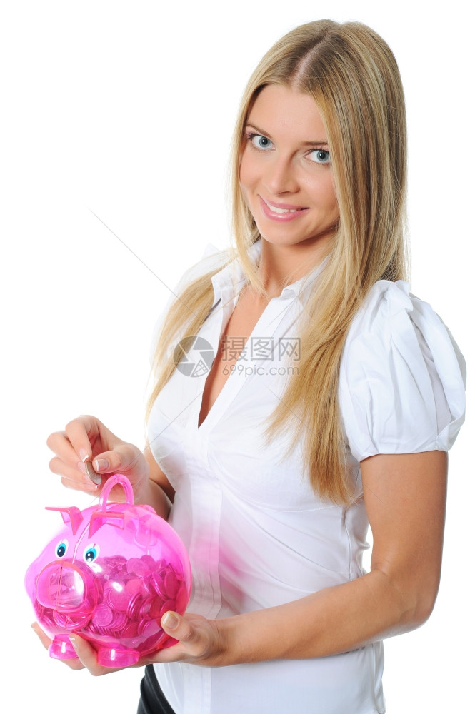 美丽的年轻女把硬币放进小猪银行图片