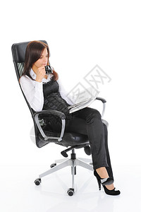 商业妇女喝咖啡在明亮办公室的椅子上看书图片