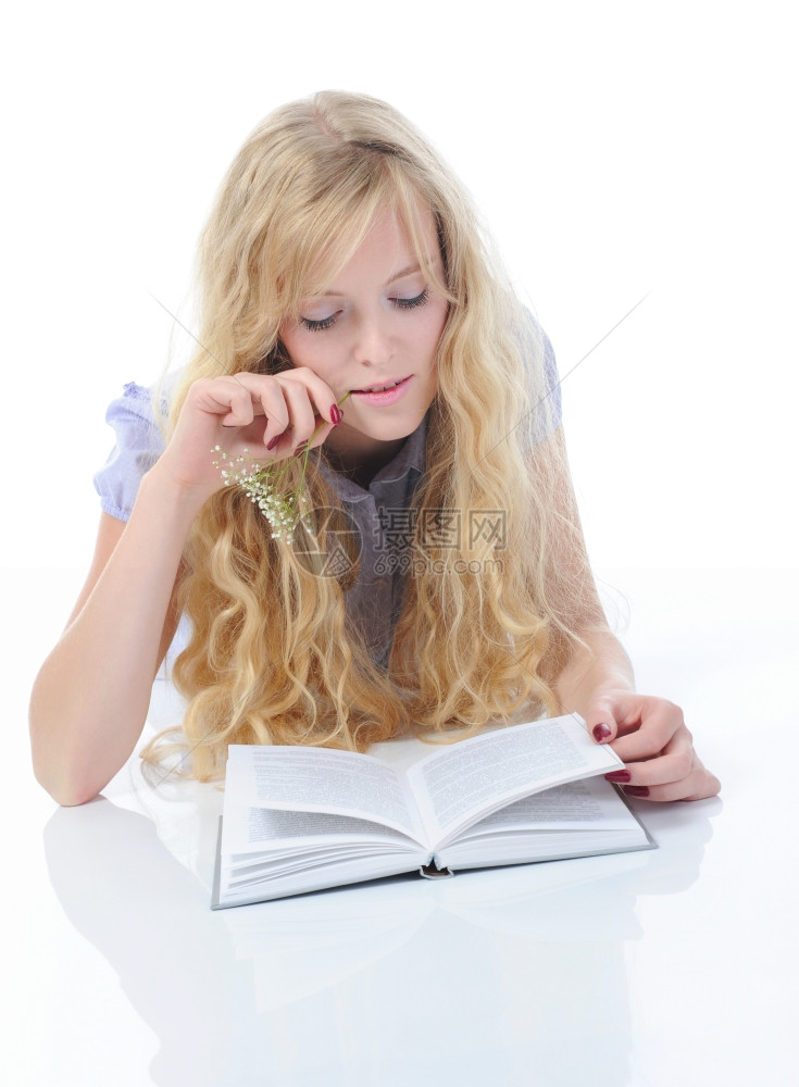 年轻女孩躺在一个明亮房间的地板上读书孤立在白色背景上图片