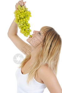 年轻金发女孩吃葡萄孤立于白种背景背景图片