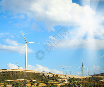 山丘阳光明媚日的大型风车照片图片