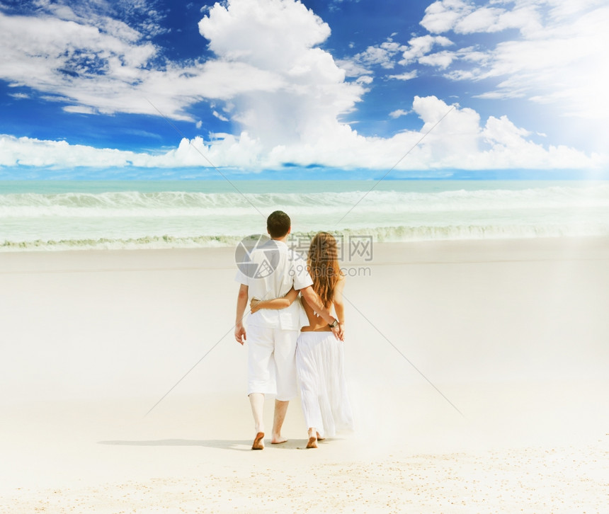 在阳光明媚的海滩上年轻美夫妇图片