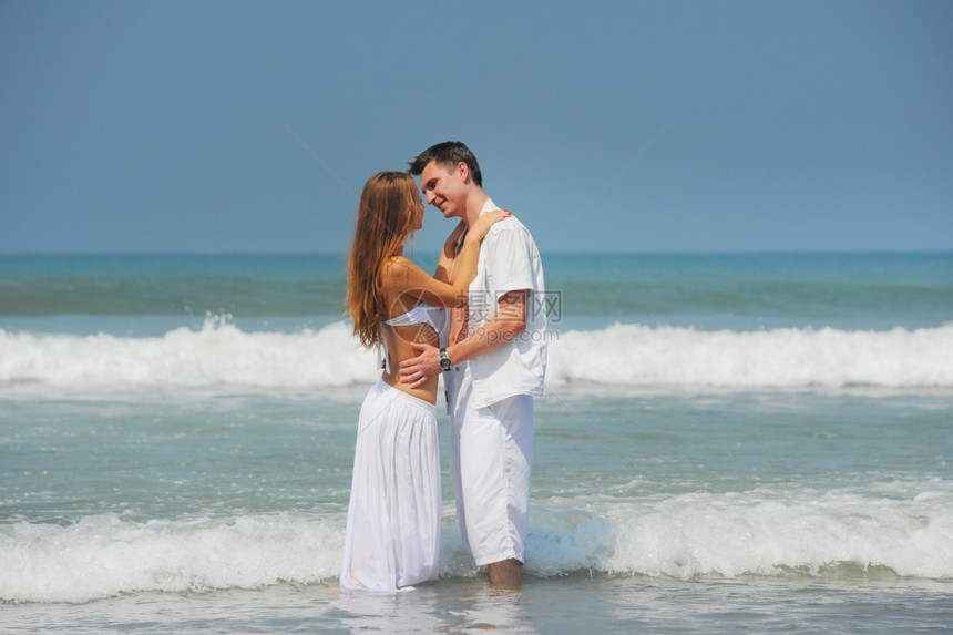 在阳光明媚的海滩上相爱年轻美夫妻图片