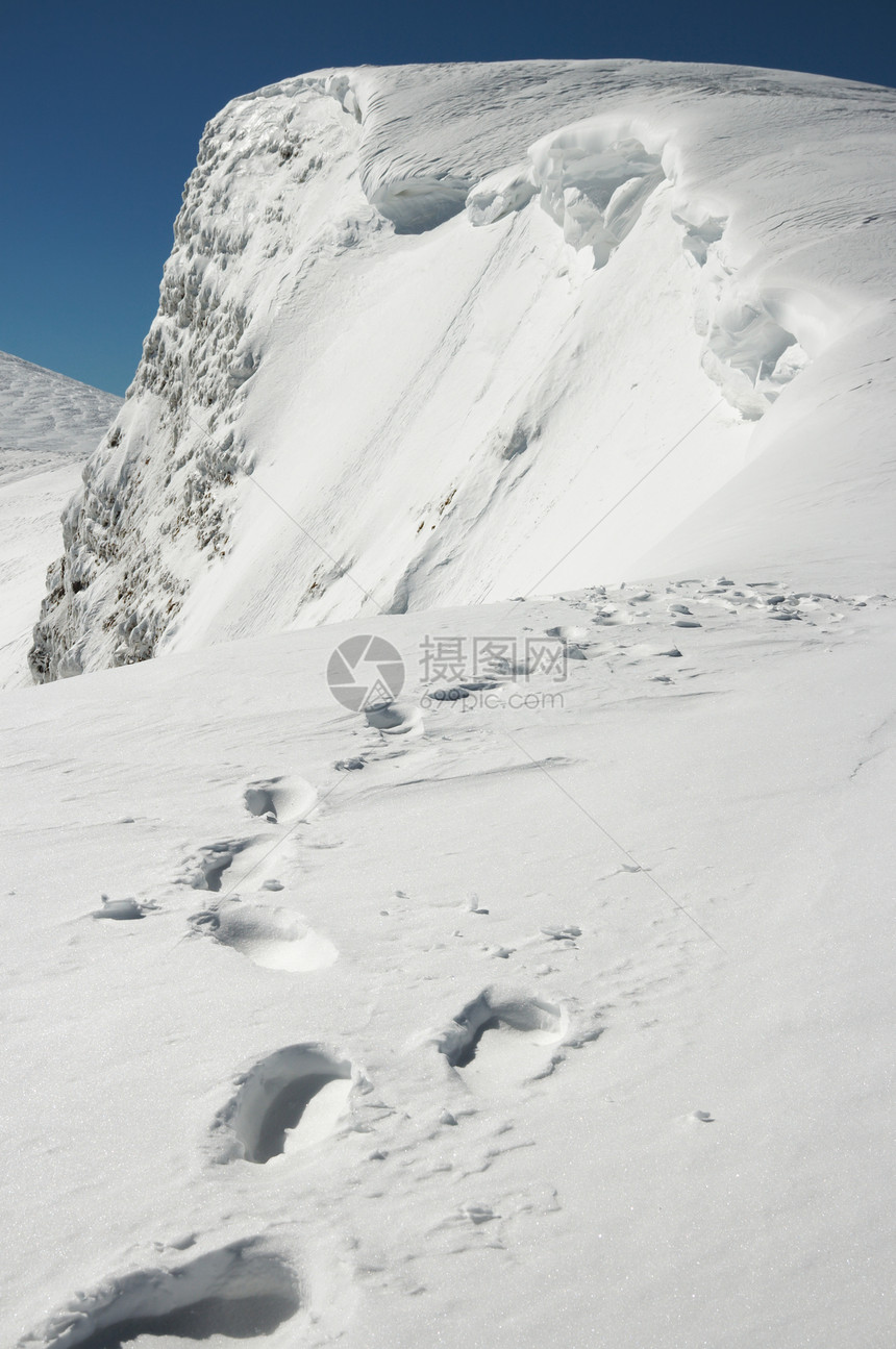 寒冬陡峭的悬崖壁和雪上人类足迹接连到悬崖边乌克兰喀尔巴阡山斯维多茨海脊布雷兹尼察山图片