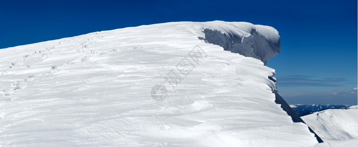 冬季山顶有仙子上悬的雪帽和山边人类足迹对摄影三脚架进行跟踪五针缝合图图片